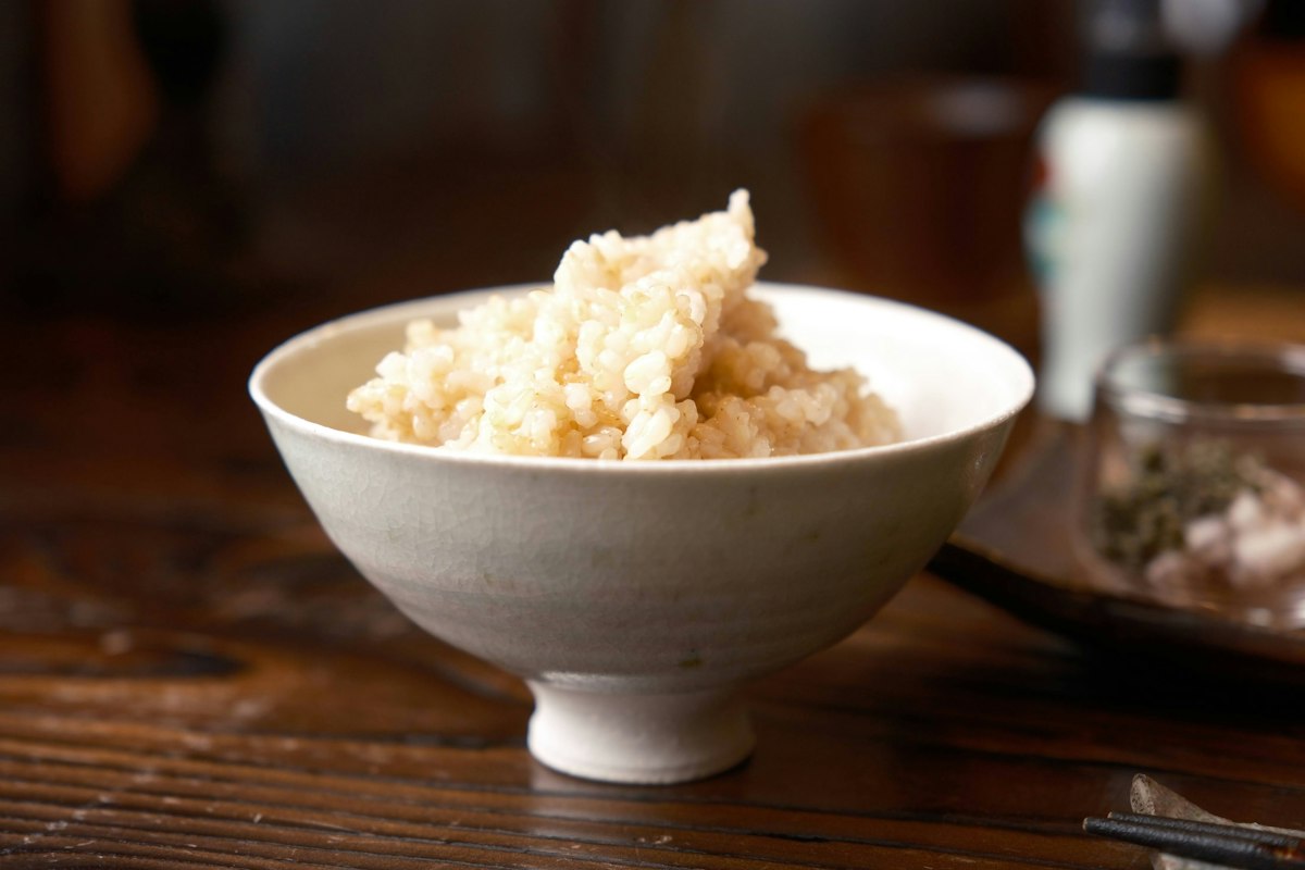 木のテーブルの上に置かれたご飯の茶碗